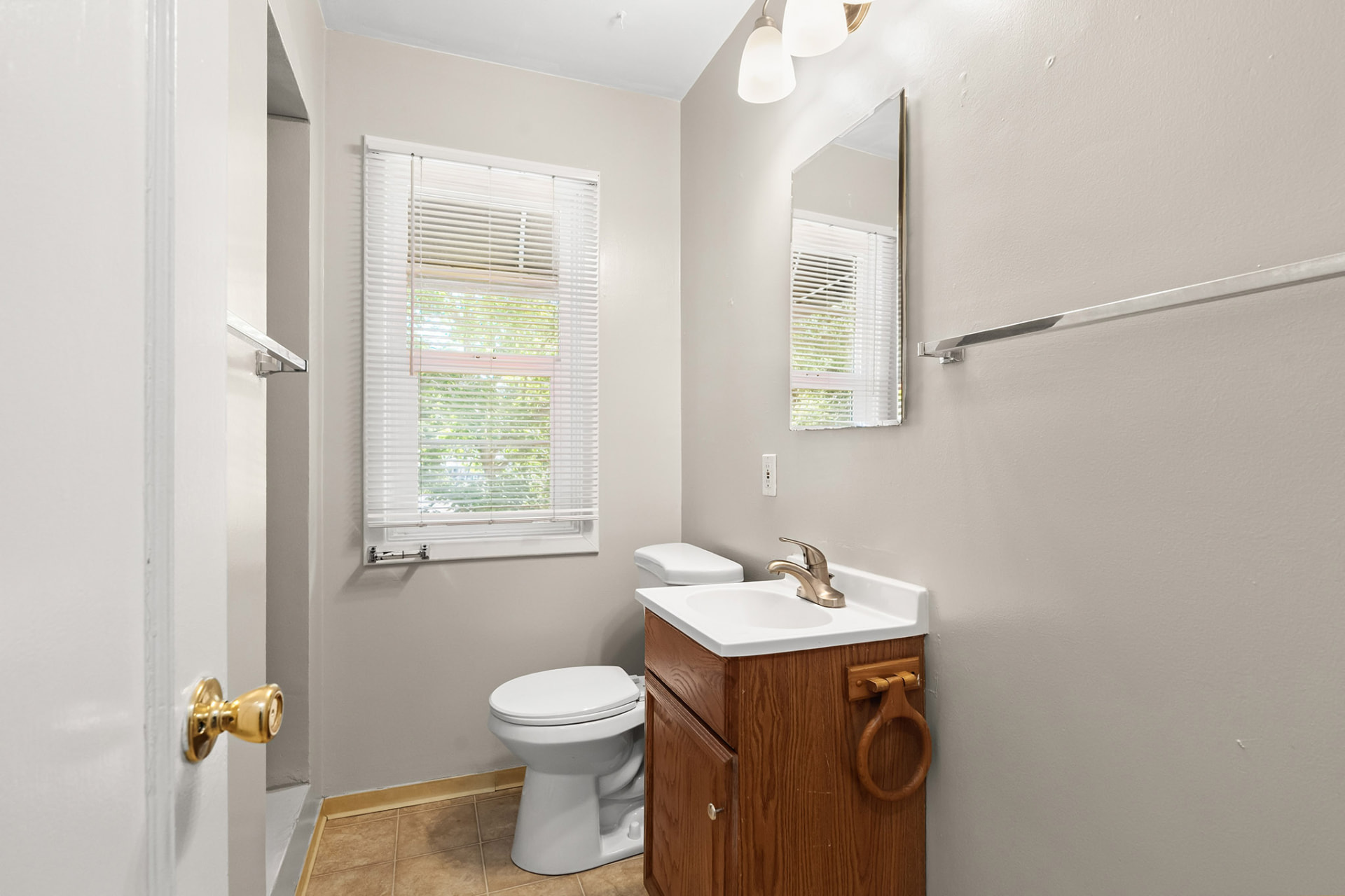 Unit bathroom with vanity, mirror, and tile flooring