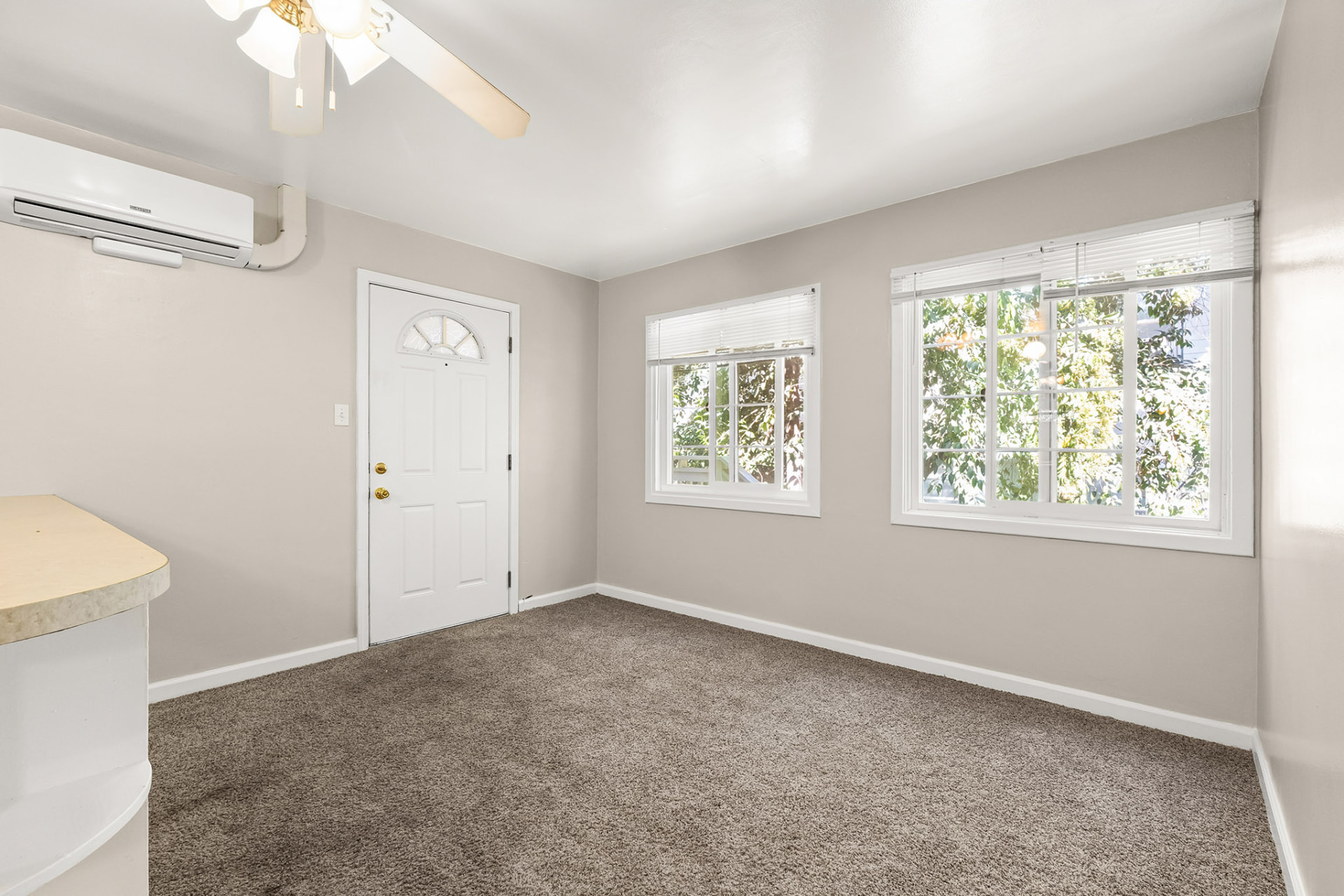 Living room with mini-split heating and cooling unit and dual windows